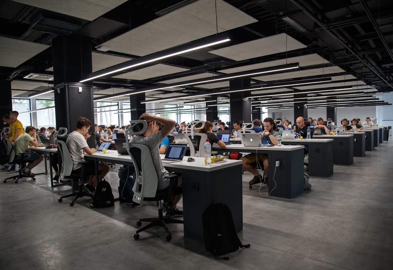 A busy open-plan office with teams working at their desks