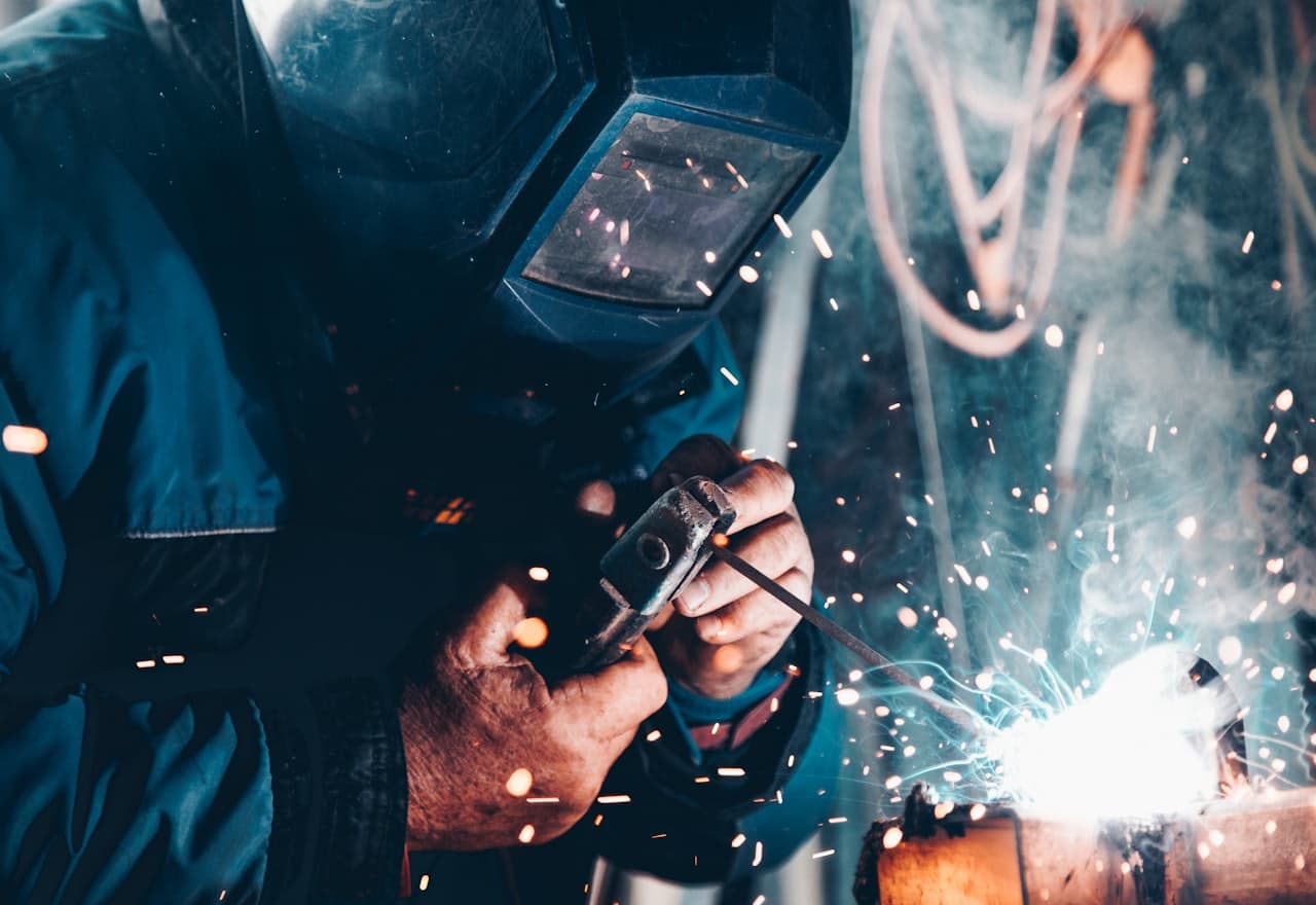 A welder at work on a production line, sparks flying